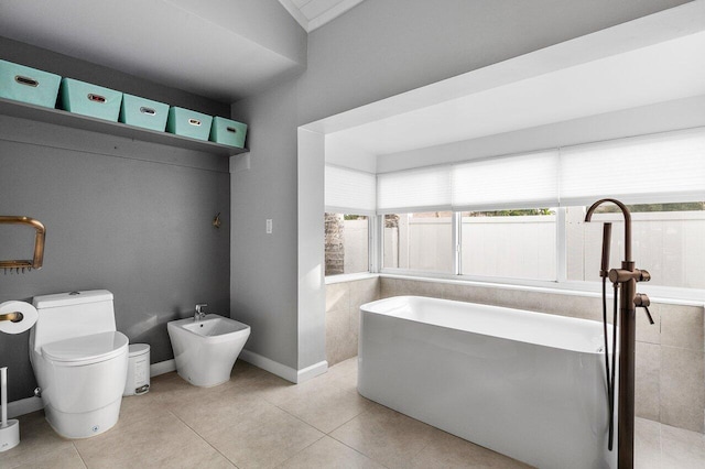 bathroom with toilet, tile patterned flooring, and a bidet