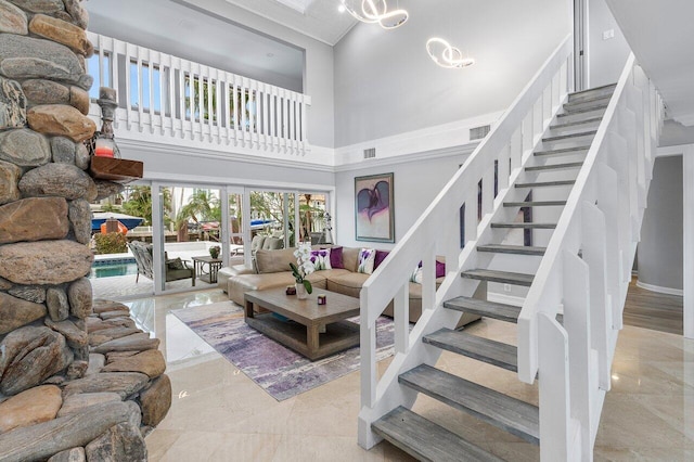 living room with a towering ceiling and crown molding