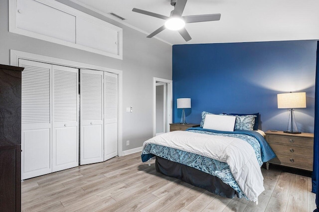 bedroom with ceiling fan, light hardwood / wood-style flooring, ornamental molding, and a closet