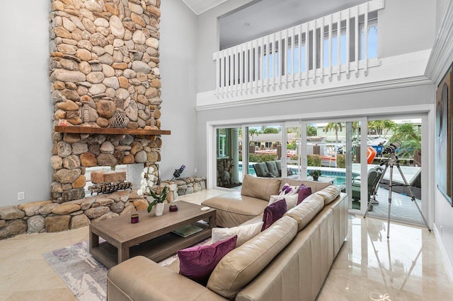 living room with a high ceiling, a fireplace, and a healthy amount of sunlight