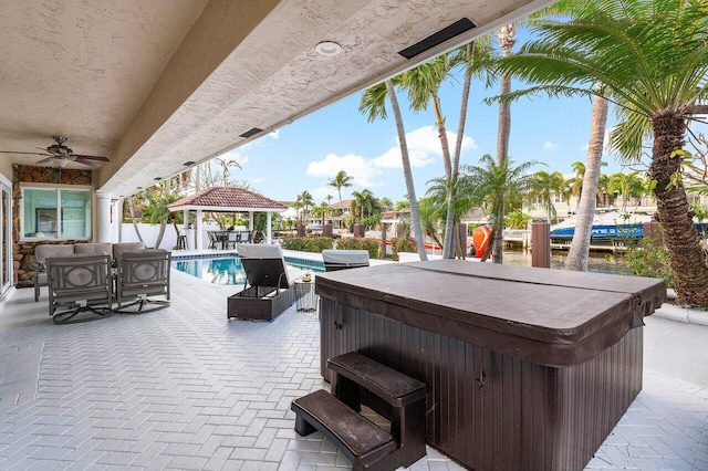 view of patio / terrace with an outdoor bar, a gazebo, and a pool with hot tub