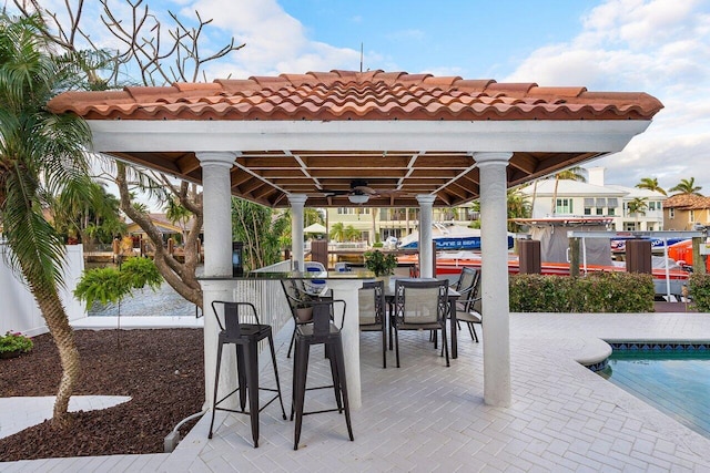 view of patio featuring an outdoor bar and ceiling fan