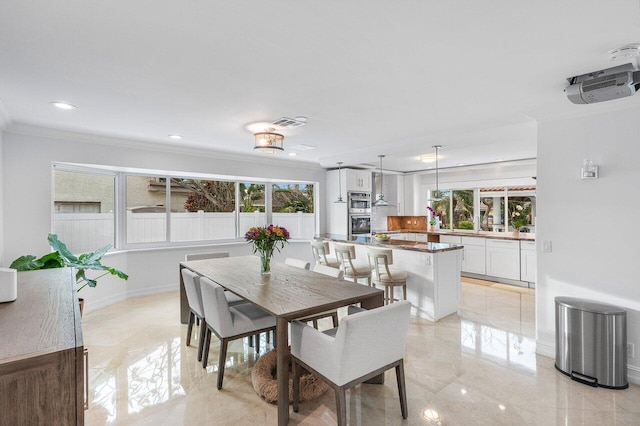 dining area with a healthy amount of sunlight and ornamental molding