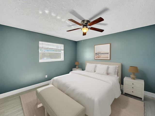 bedroom with ceiling fan, light hardwood / wood-style floors, and a textured ceiling