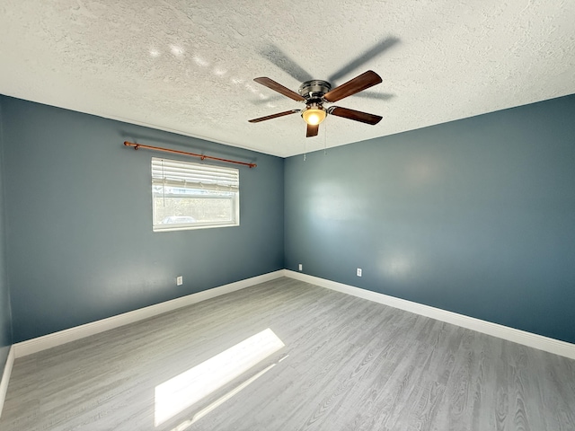 spare room with a textured ceiling, ceiling fan, and light hardwood / wood-style flooring