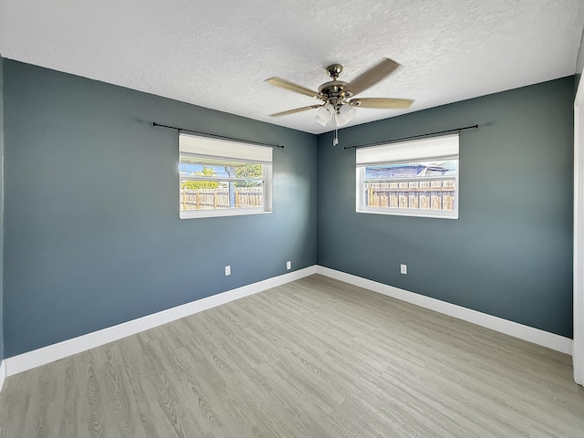 empty room with a textured ceiling, ceiling fan, and light wood-type flooring