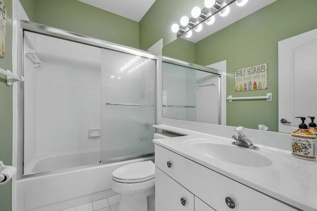 full bathroom with tile patterned floors, combined bath / shower with glass door, vanity, and toilet