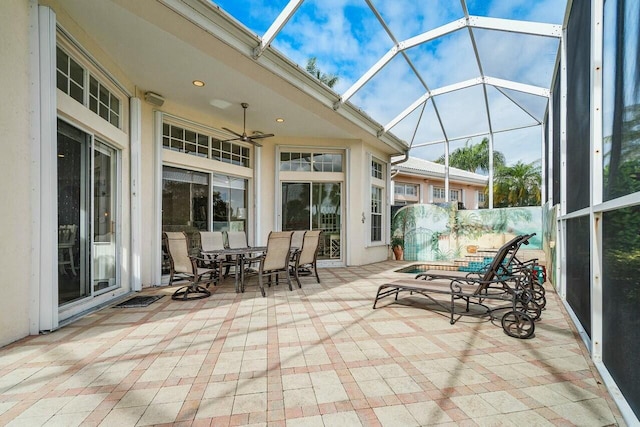 unfurnished sunroom with ceiling fan