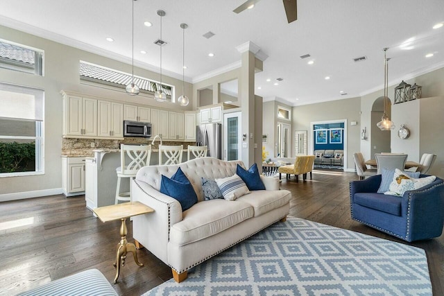 living room with ceiling fan, a high ceiling, dark hardwood / wood-style floors, and crown molding