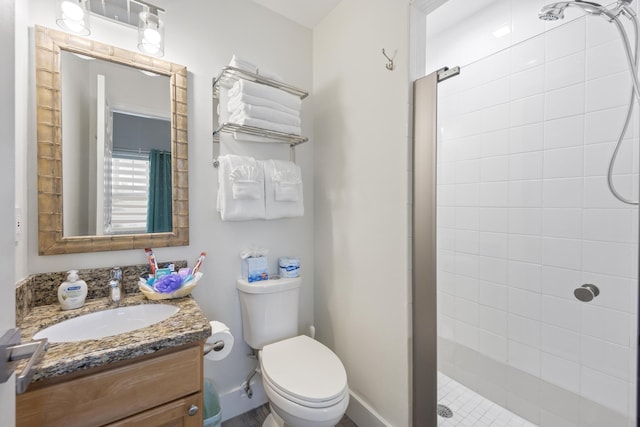 bathroom with toilet, vanity, and walk in shower