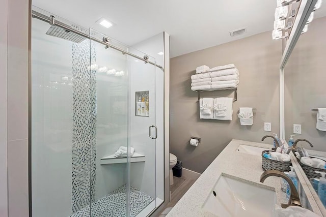 bathroom with a shower with door, wood-type flooring, toilet, and vanity