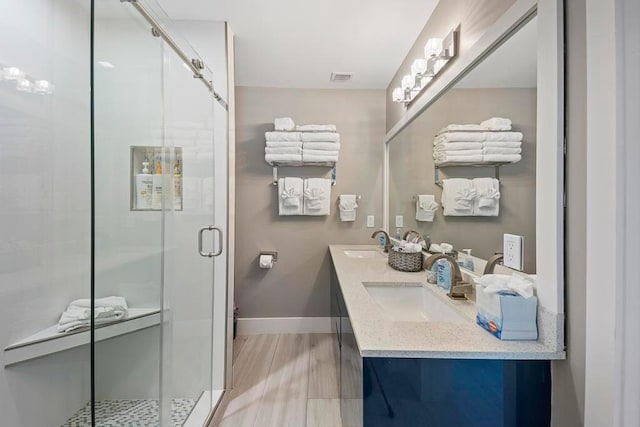 bathroom with a shower with shower door, wood-type flooring, and vanity