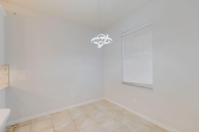 tiled empty room with a chandelier