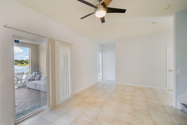 tiled spare room featuring ceiling fan