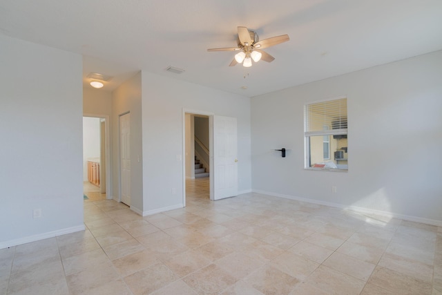 unfurnished room with ceiling fan and light tile patterned floors