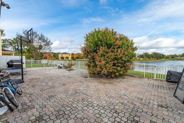 view of patio with a grill and a water view