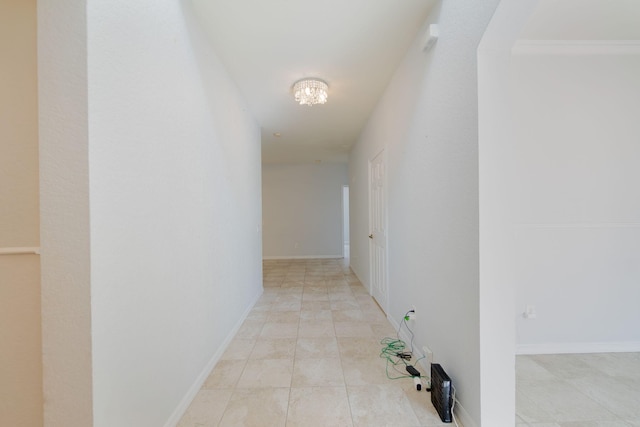 hall featuring light tile patterned floors and ornamental molding