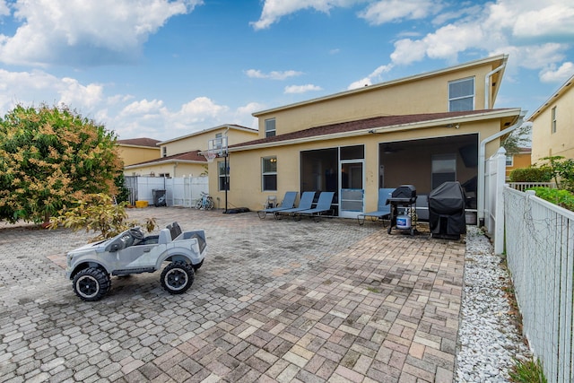 back of property with a sunroom and a patio