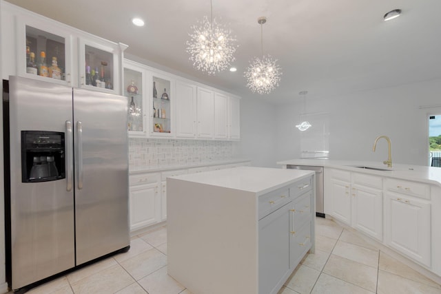 kitchen with white cabinetry, appliances with stainless steel finishes, backsplash, hanging light fixtures, and a center island