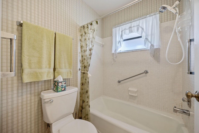 bathroom featuring toilet and shower / bath combination with curtain