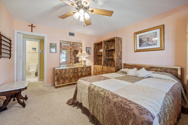 bedroom with ceiling fan, connected bathroom, and a textured ceiling