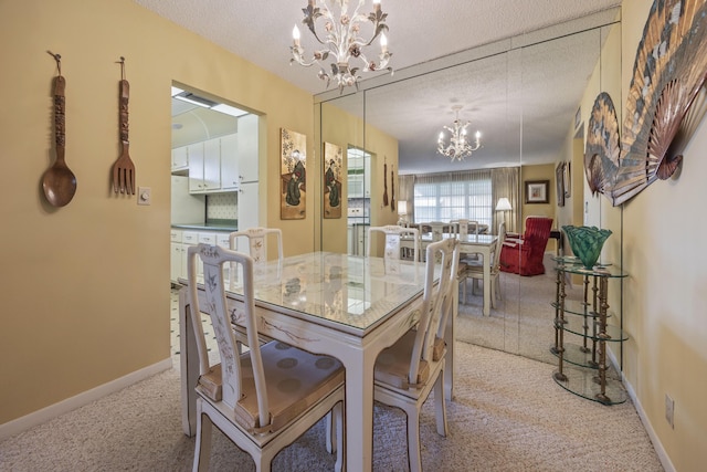 dining area with light colored carpet, a textured ceiling, and a notable chandelier