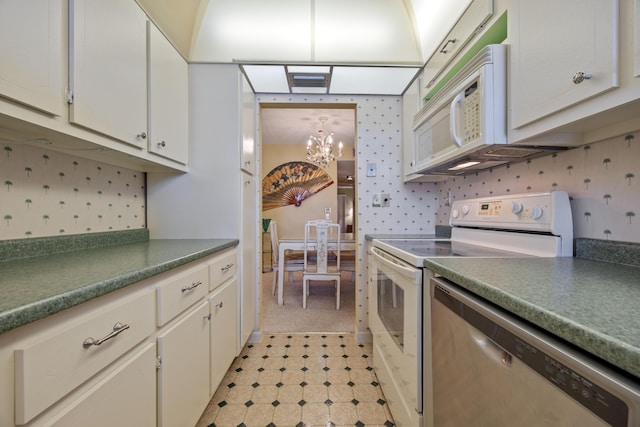 kitchen with white appliances, white cabinets, and a chandelier