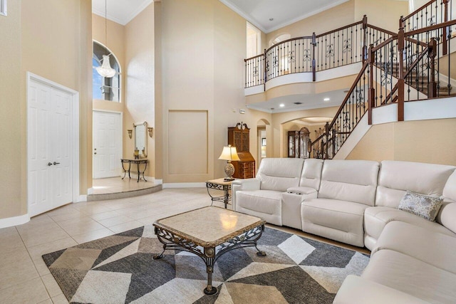 tiled living room featuring crown molding and a towering ceiling