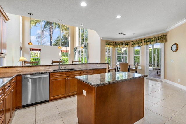 kitchen with dishwasher, pendant lighting, a kitchen island, dark stone countertops, and sink