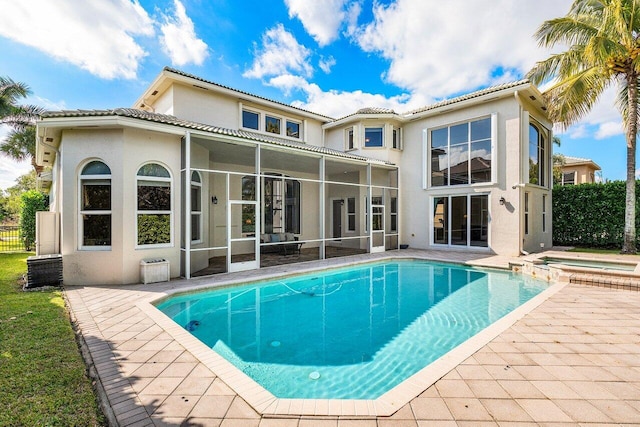 back of house featuring a pool with hot tub and a patio