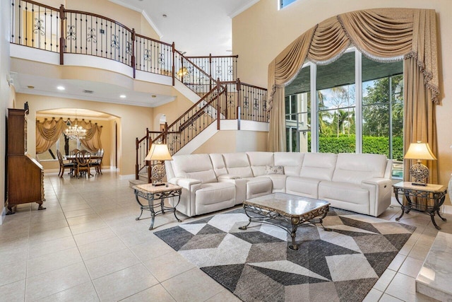 tiled living room with a high ceiling, an inviting chandelier, plenty of natural light, and crown molding