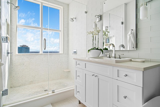 bathroom with tile patterned flooring, walk in shower, and vanity