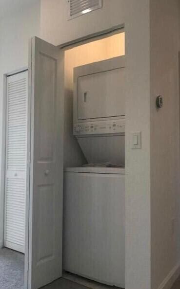 laundry room with stacked washer / drying machine