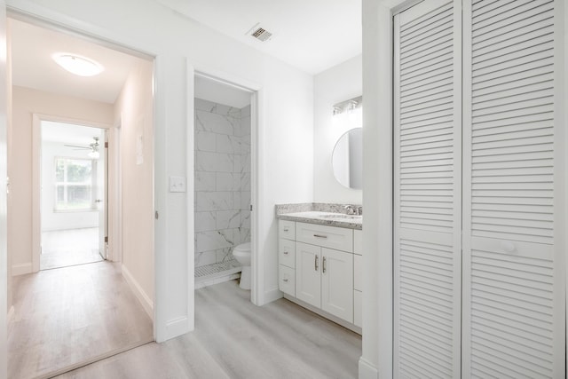 bathroom with toilet, ceiling fan, vanity, and hardwood / wood-style floors