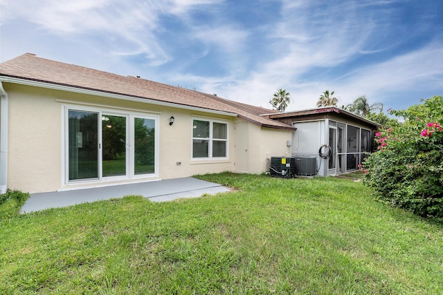 rear view of property featuring central air condition unit, a yard, and a patio