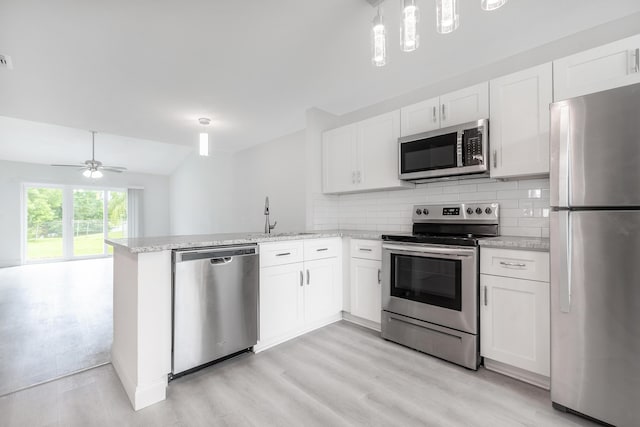 kitchen with stainless steel appliances, white cabinets, and kitchen peninsula