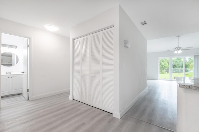 hallway with sink and light wood-type flooring