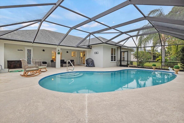 view of pool with a patio and glass enclosure