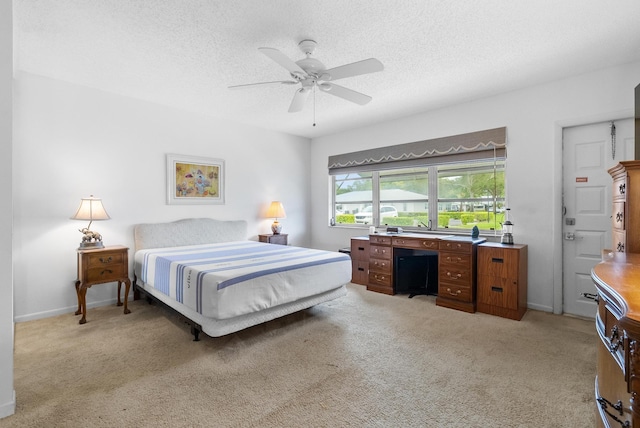 carpeted bedroom with ceiling fan and a textured ceiling