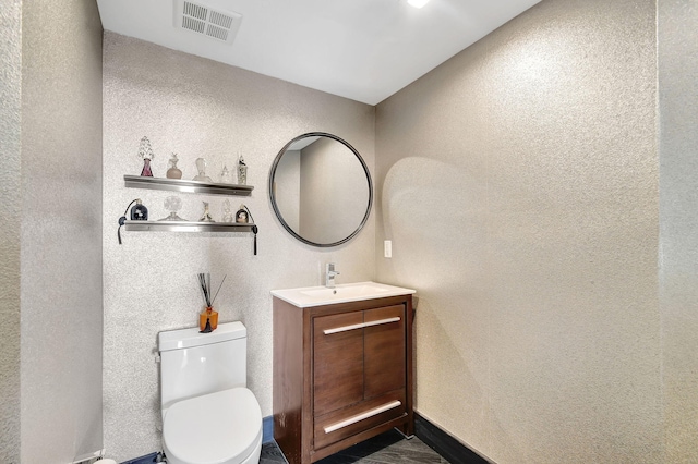 bathroom featuring toilet and vanity