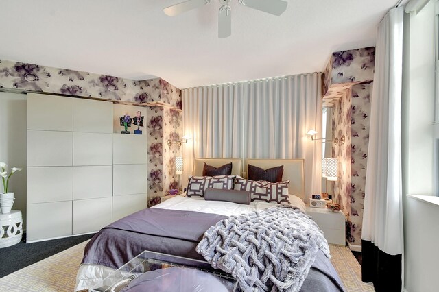 carpeted bedroom with ceiling fan and multiple windows