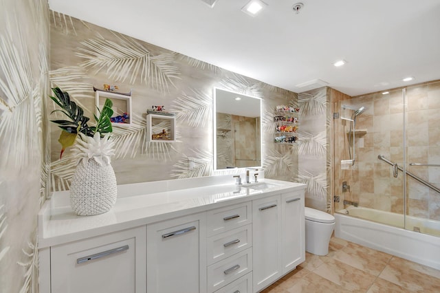 full bathroom featuring toilet, shower / bath combination with glass door, and vanity