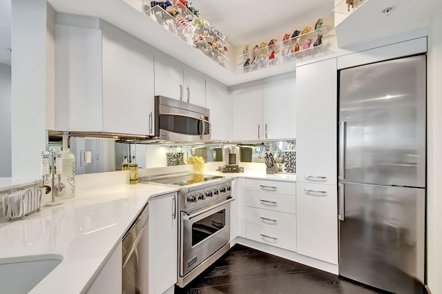 kitchen with premium appliances, dark hardwood / wood-style floors, and white cabinetry