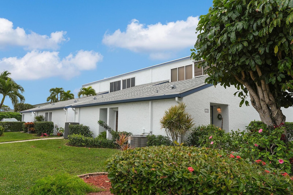 exterior space featuring cooling unit and a lawn