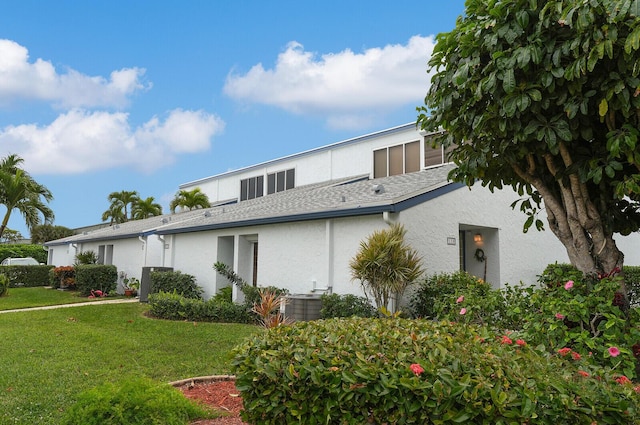 exterior space featuring cooling unit and a lawn