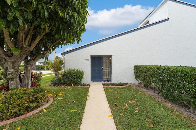 entrance to property featuring a yard