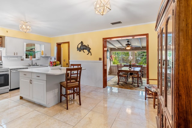 kitchen featuring ceiling fan with notable chandelier, a center island, decorative light fixtures, white cabinetry, and stainless steel appliances