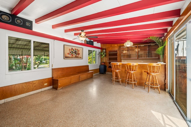 reception area with ceiling fan and bar area