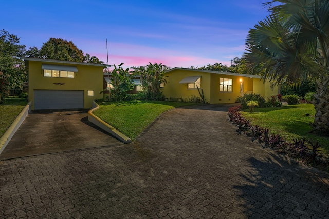 view of front of house with a garage and a yard