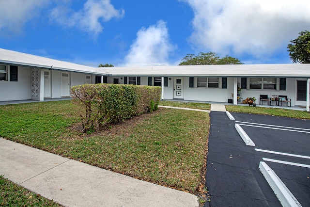 ranch-style home with a front yard and covered porch